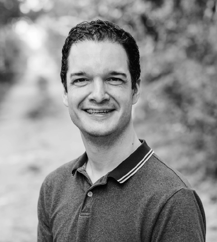 A black and white portrait of a smiling man named Joe